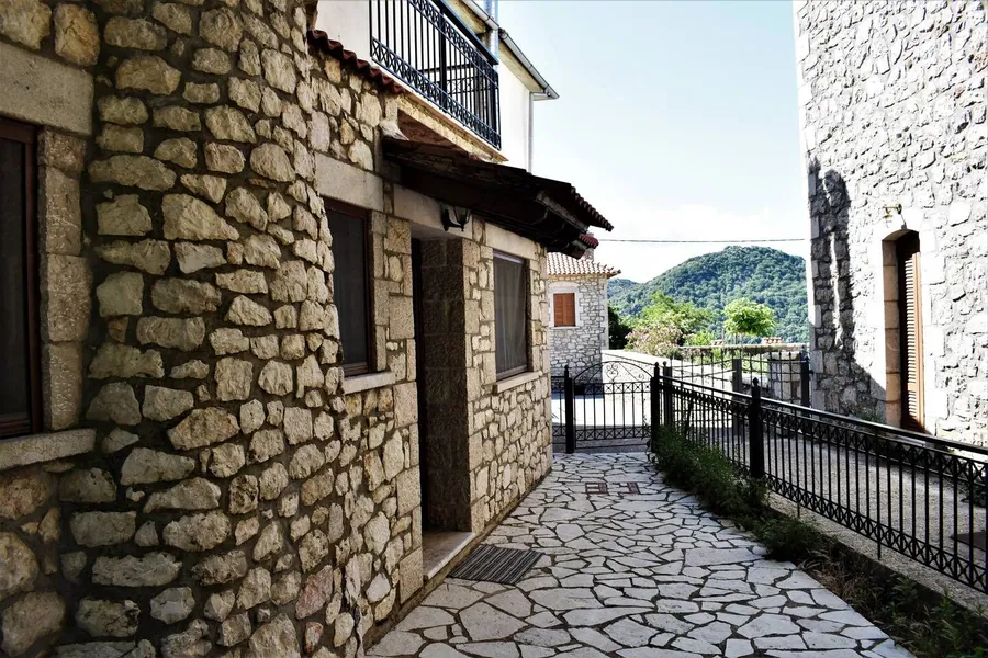 Πέτρινο σοκάκι με πλακόστρωτο δίπλα στο σπίτι